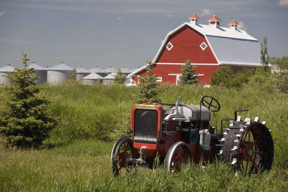 DPI1882123 Old Red Tractor In A Field with A Red Barn In The Background - Alberta, Canada Poster Print, 19 x 12