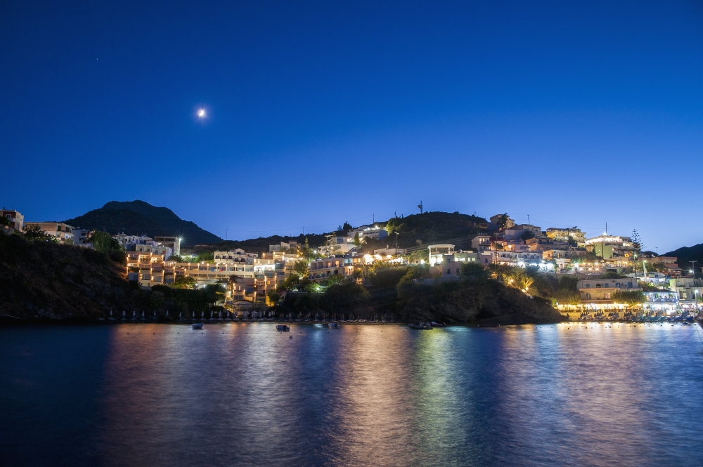 DPI12254295 Lights Illuminate The City & Reflect on The Water - Bali Crete Greece Poster Print - 19 x 12 in.