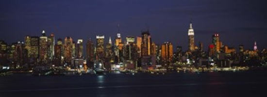 Picture of Panoramic Images PPI100358L Skyscrapers lit up at night in a city  Manhattan  New York City  New York State  USA Poster Print by Panoramic Images - 36 x 12